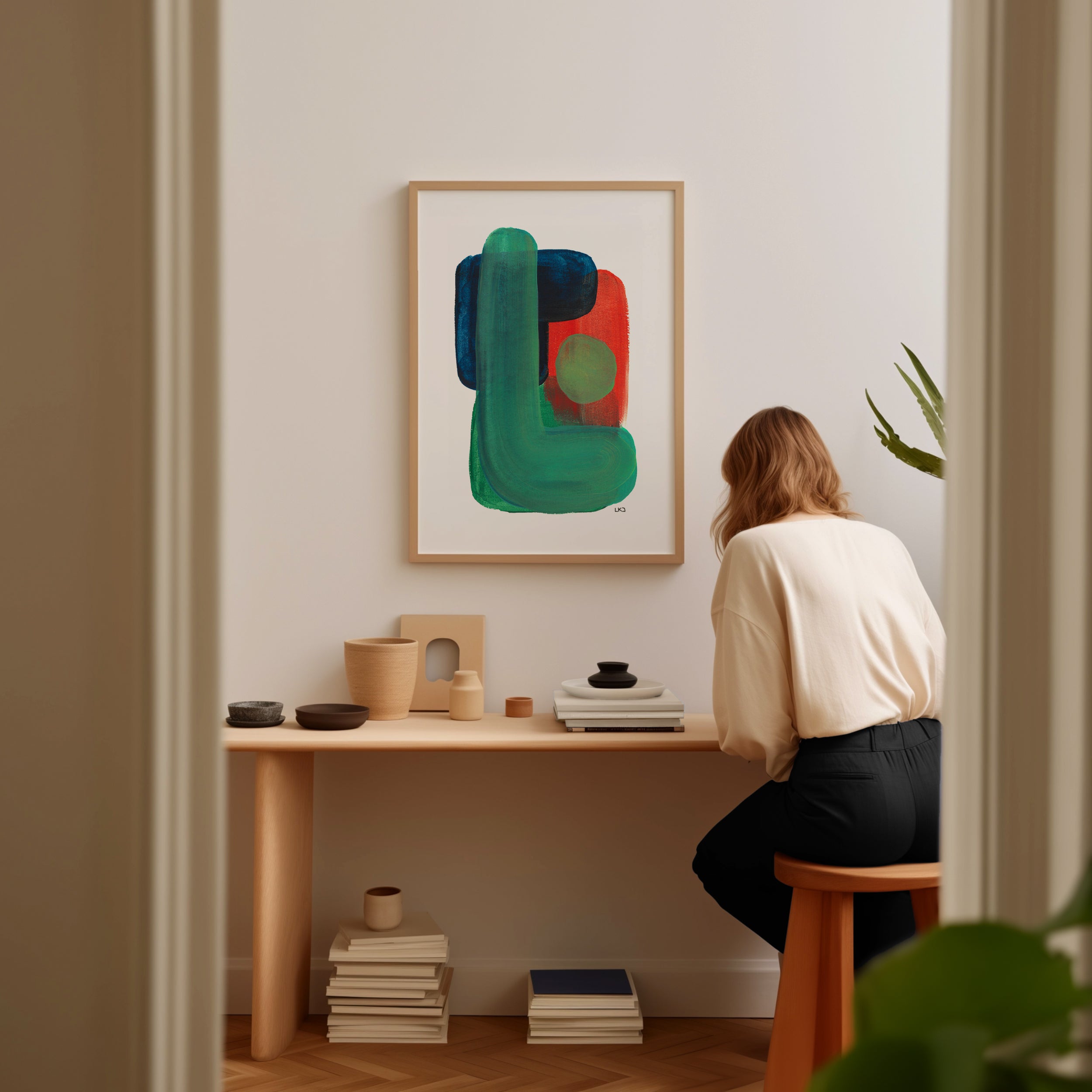 Person sitting at a desk in a room with a colorful abstract painting on the wall.